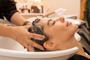 a woman getting her hair washed in a sink