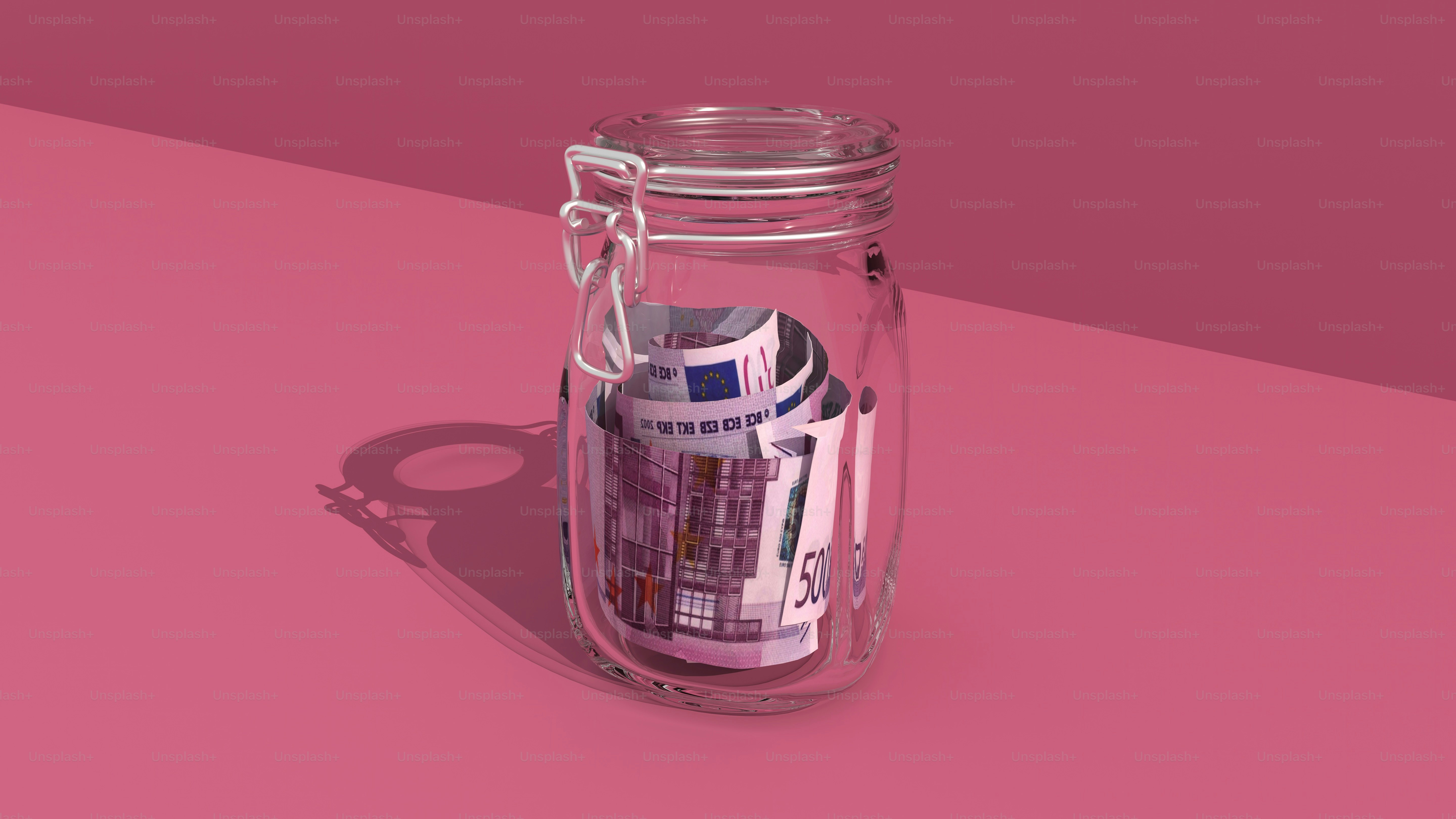 a jar filled with money sitting on top of a pink surface