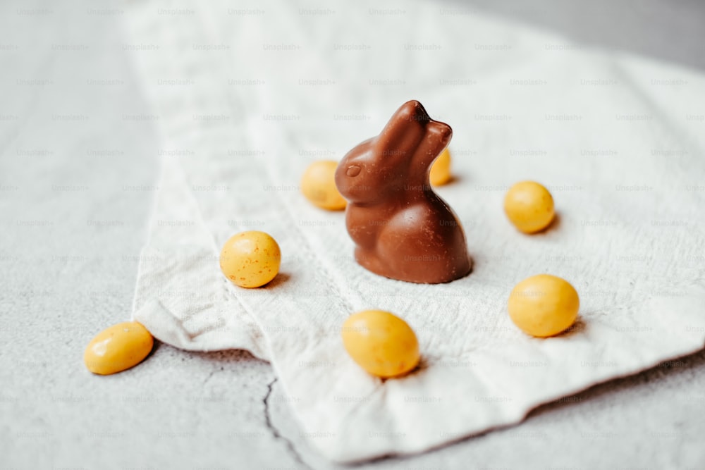 um coelho de chocolate sentado em cima de uma toalha