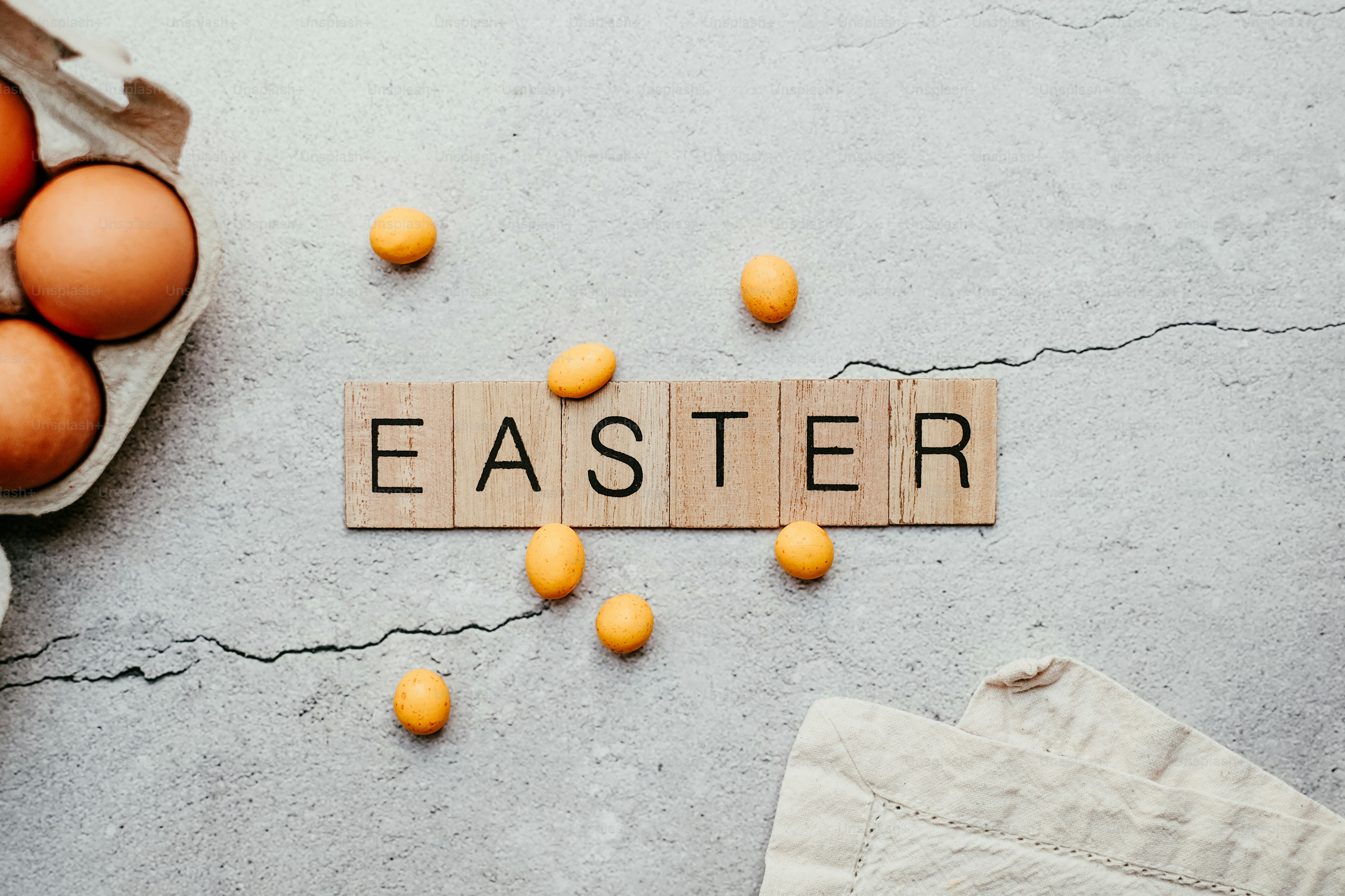 Un bloque de madera que dice Pascua rodeado de huevos