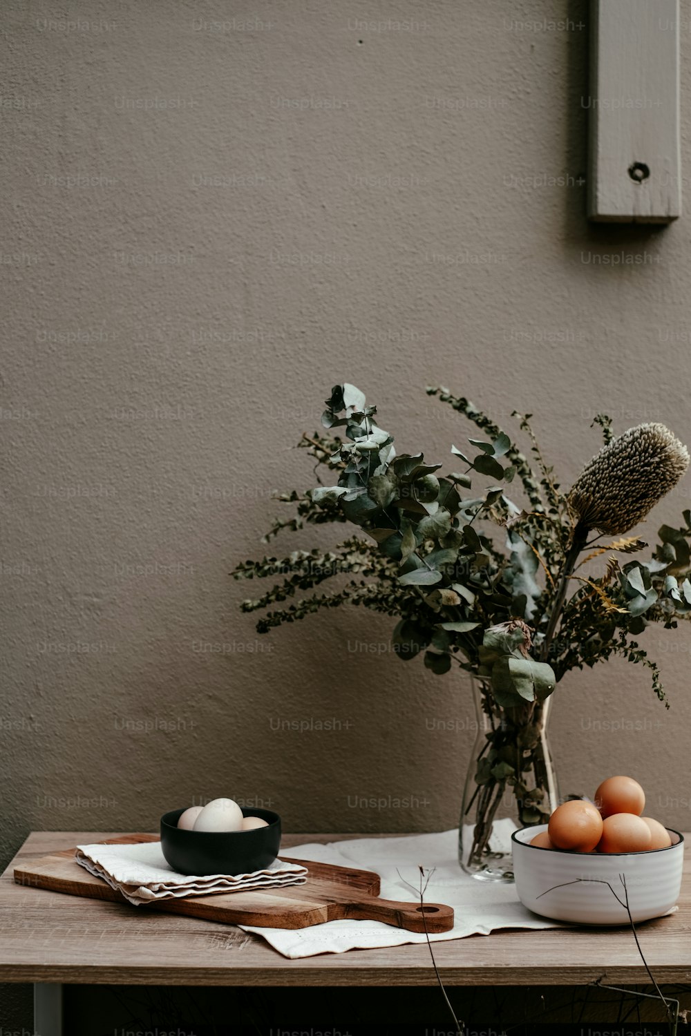 Un jarrón de flores y huevos sobre una mesa