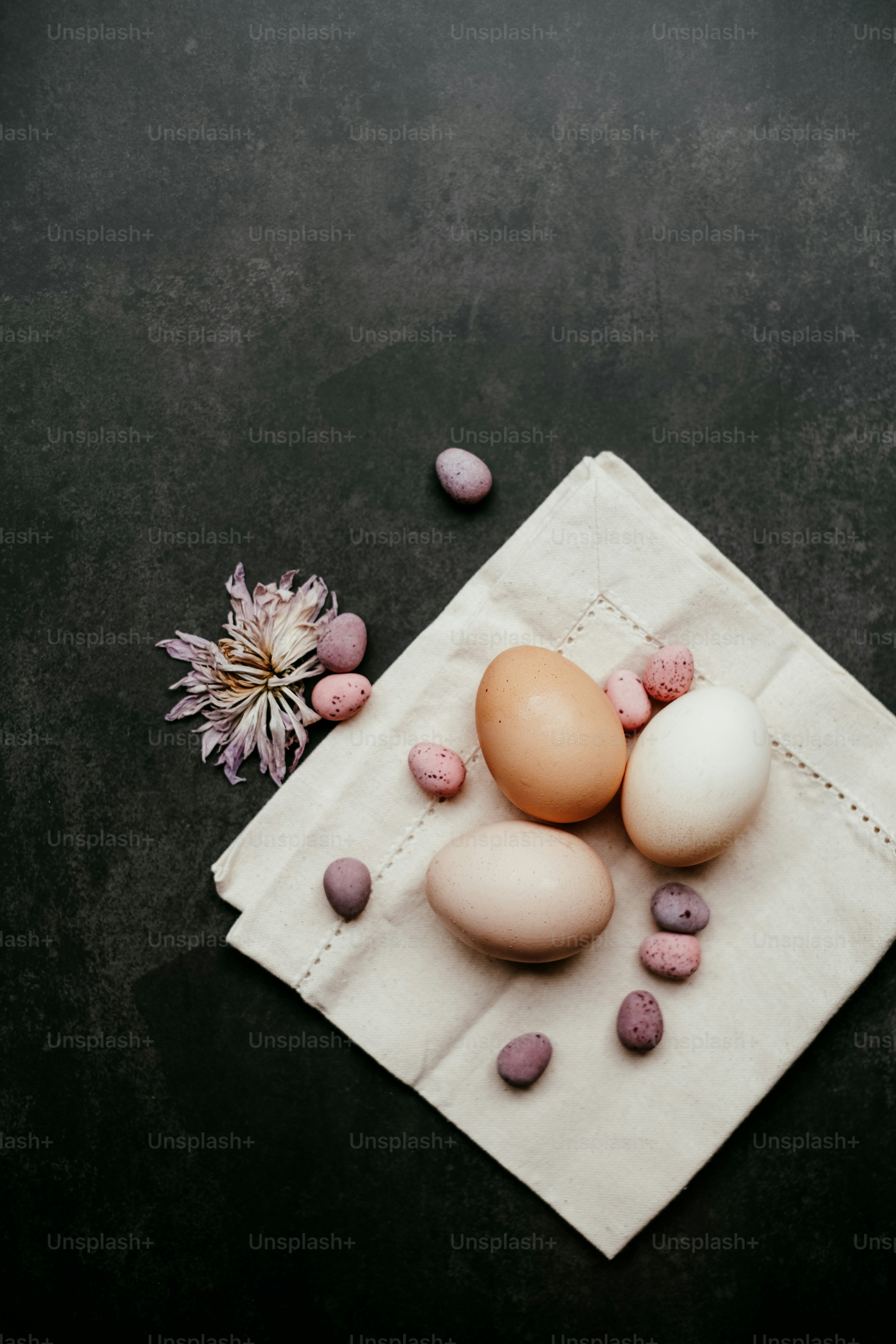 three eggs are sitting on a napkin next to a flower