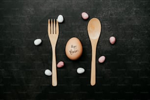 uma colher de pau, garfo e ovo em uma mesa