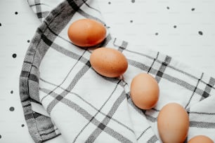 Tres huevos marrones sentados encima de una toalla blanca