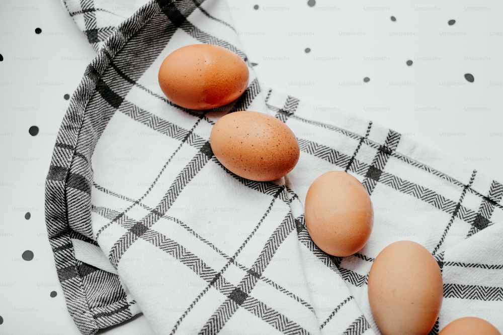 three brown eggs sitting on top of a white towel