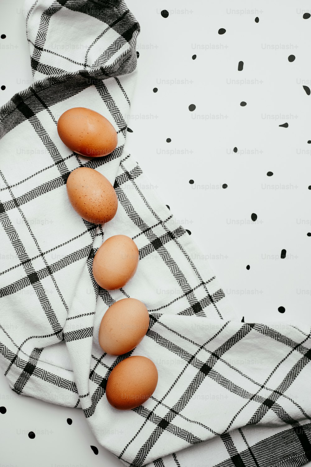 três ovos estão sentados em uma toalha em uma mesa