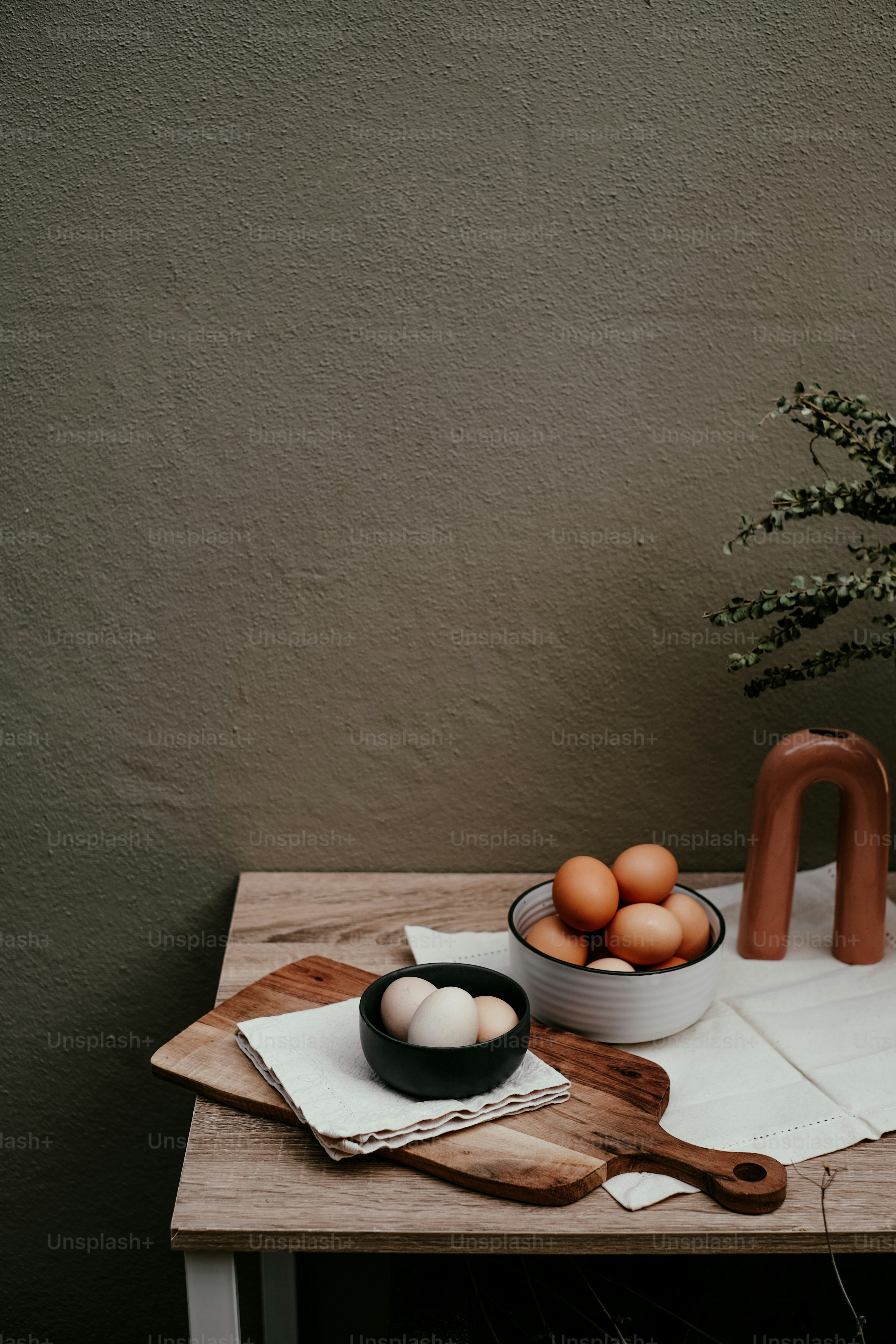 a wooden table topped with a bowl of eggs