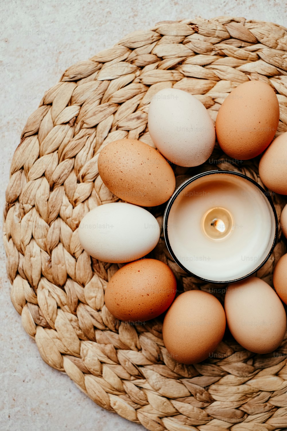 a candle is surrounded by eggs in a basket