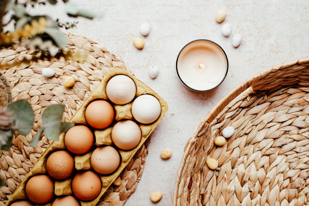 Una canasta de huevos junto a una vela sobre una mesa