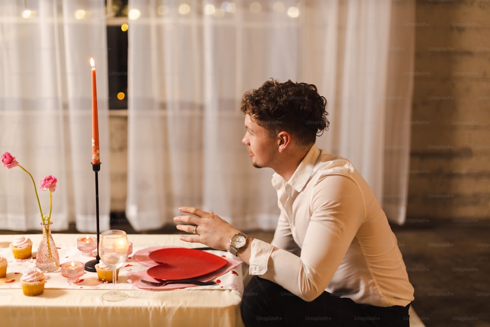 빨간 접시가 있는 테이블에 앉아 있는 남자