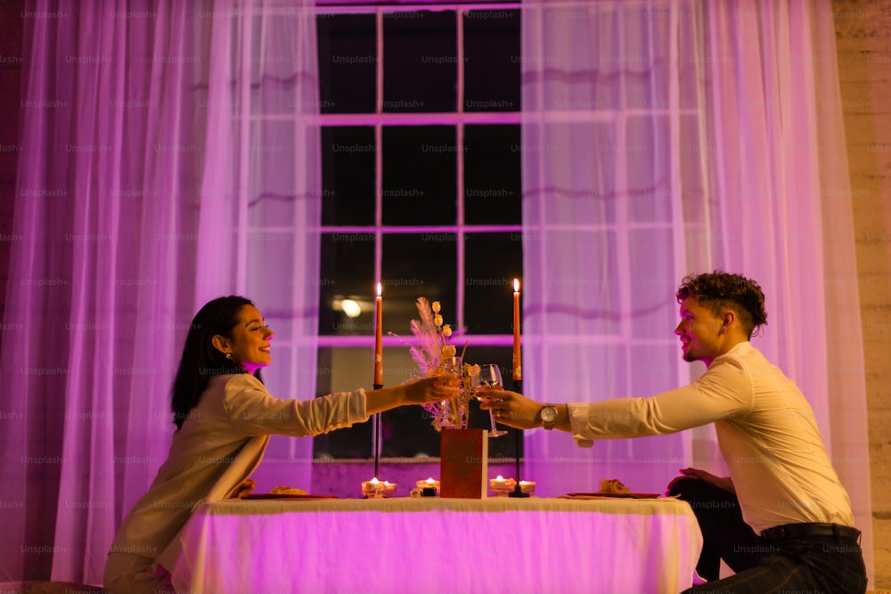 a man and a woman holding hands in front of a table with candles