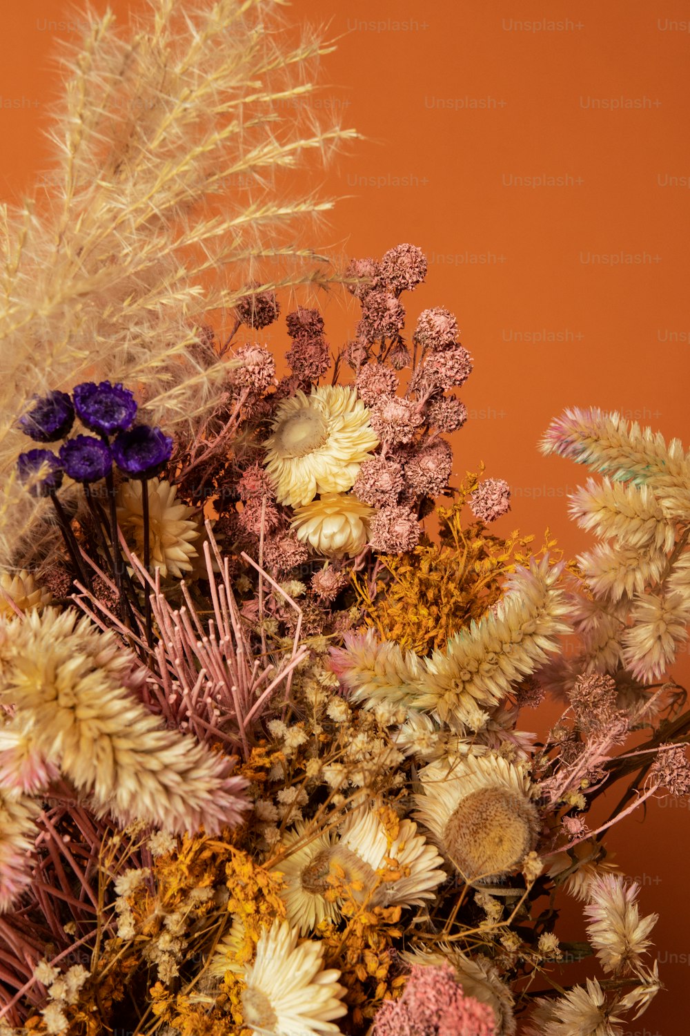 un vase rempli de nombreux types de fleurs