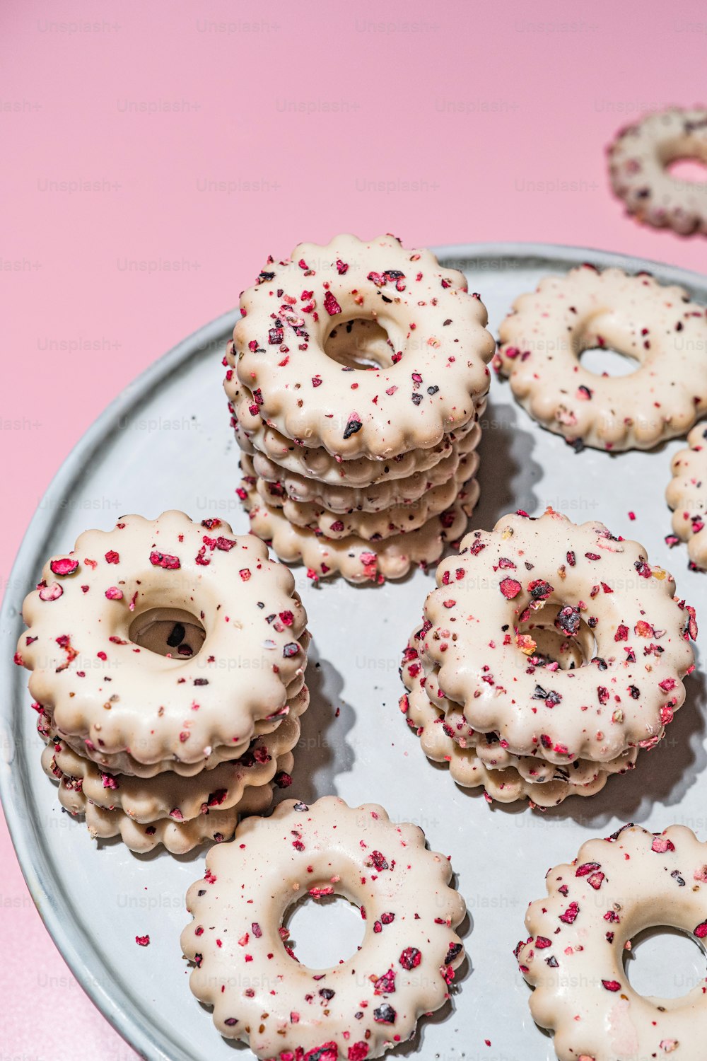 a plate of donuts with white frosting and sprinkles