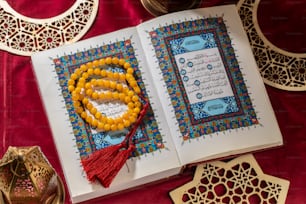 an open book with a tassel of beads on top of it