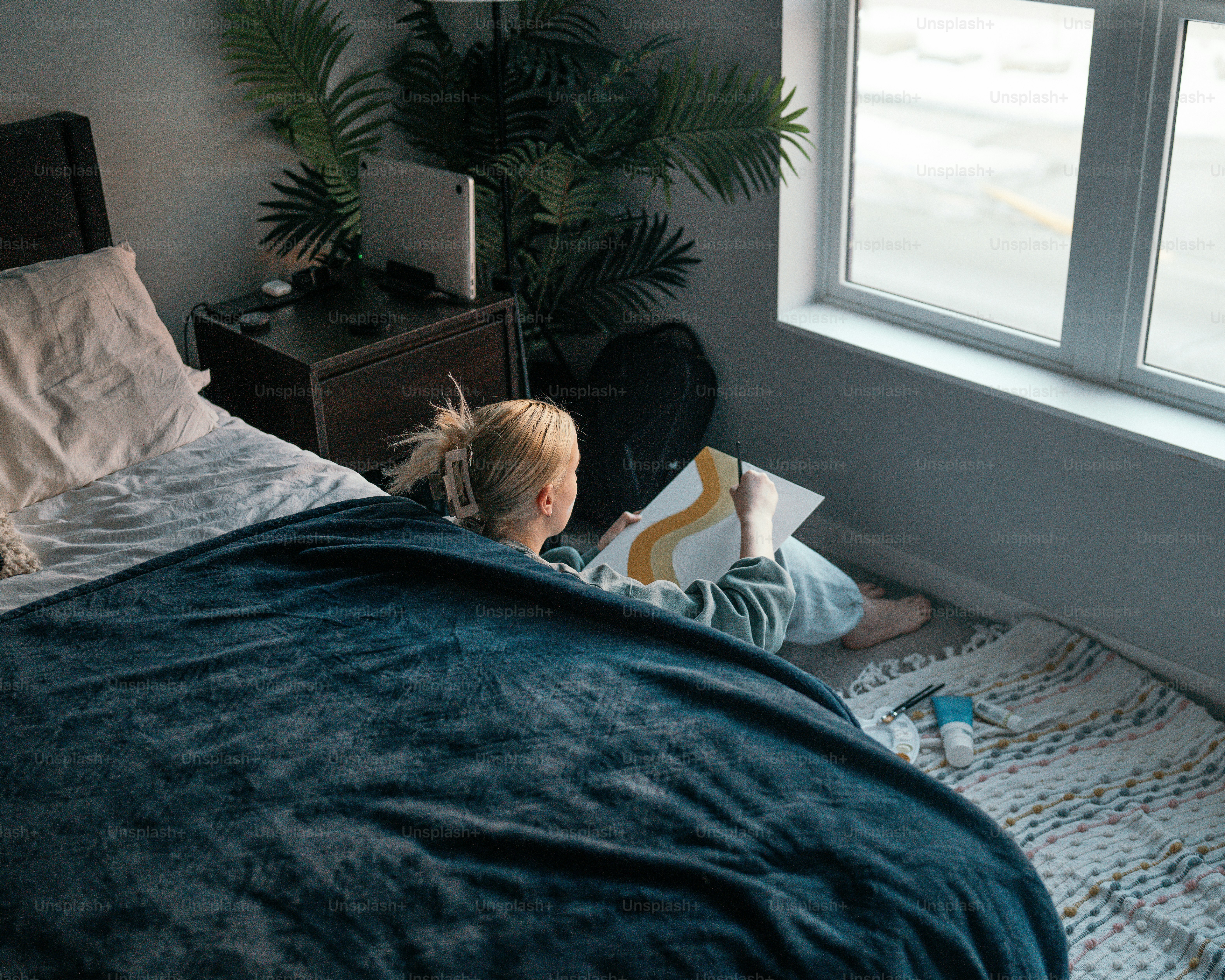 a little girl laying in bed reading a book