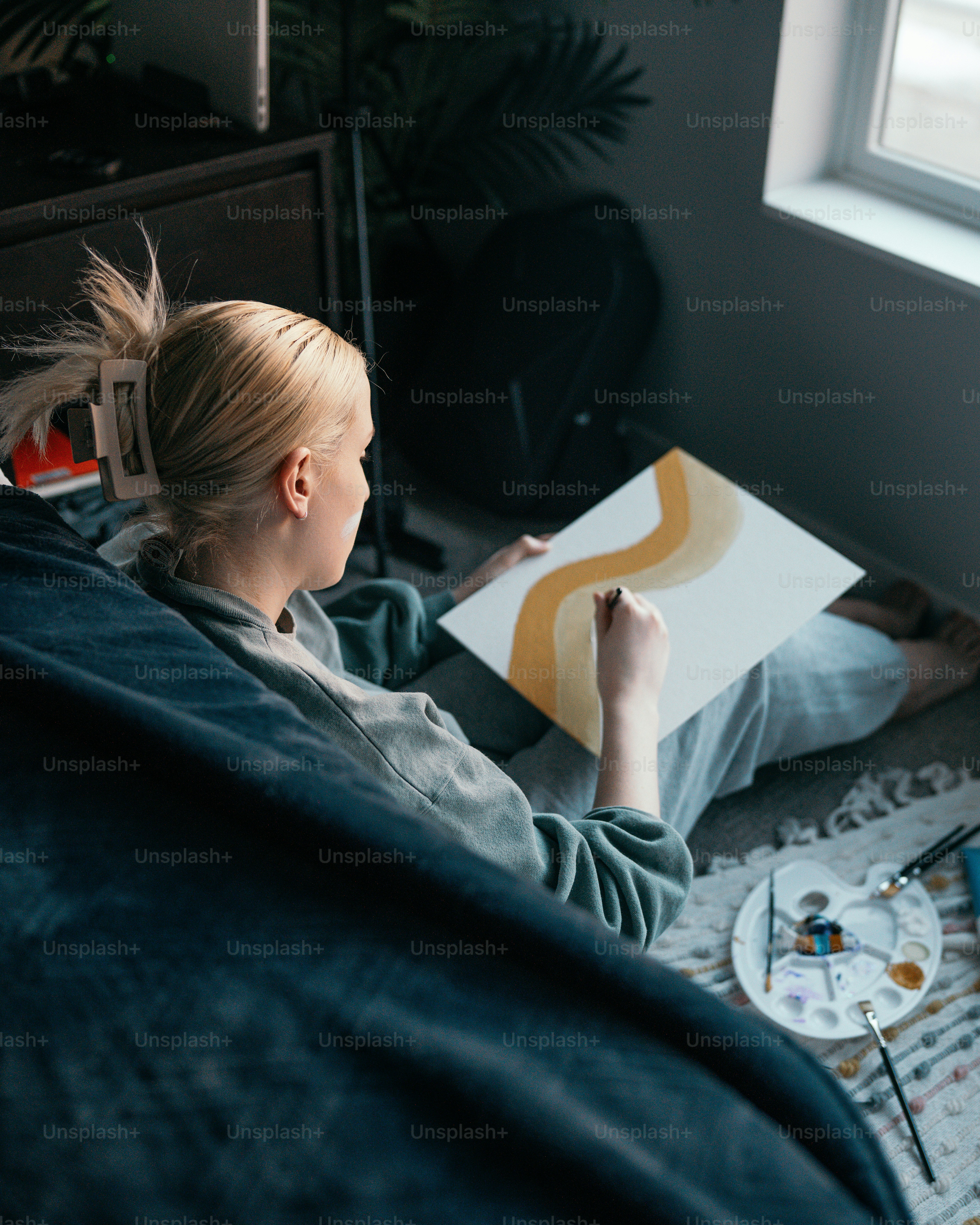 a woman sitting on a bed reading a book