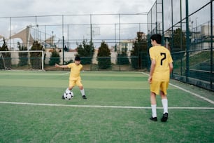 Un par de jóvenes pateando una pelota de fútbol