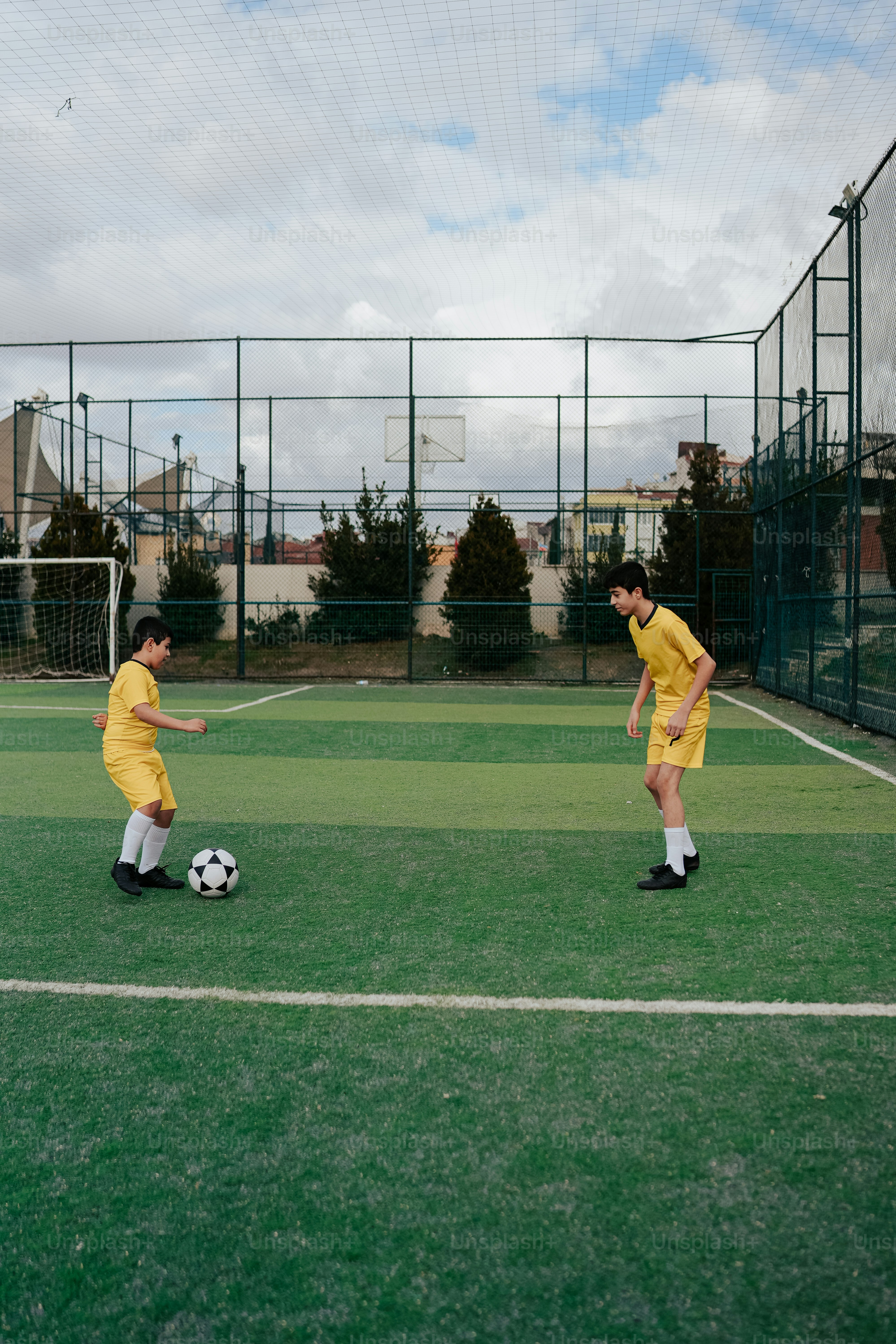 a couple of young men kicking around a soccer ball