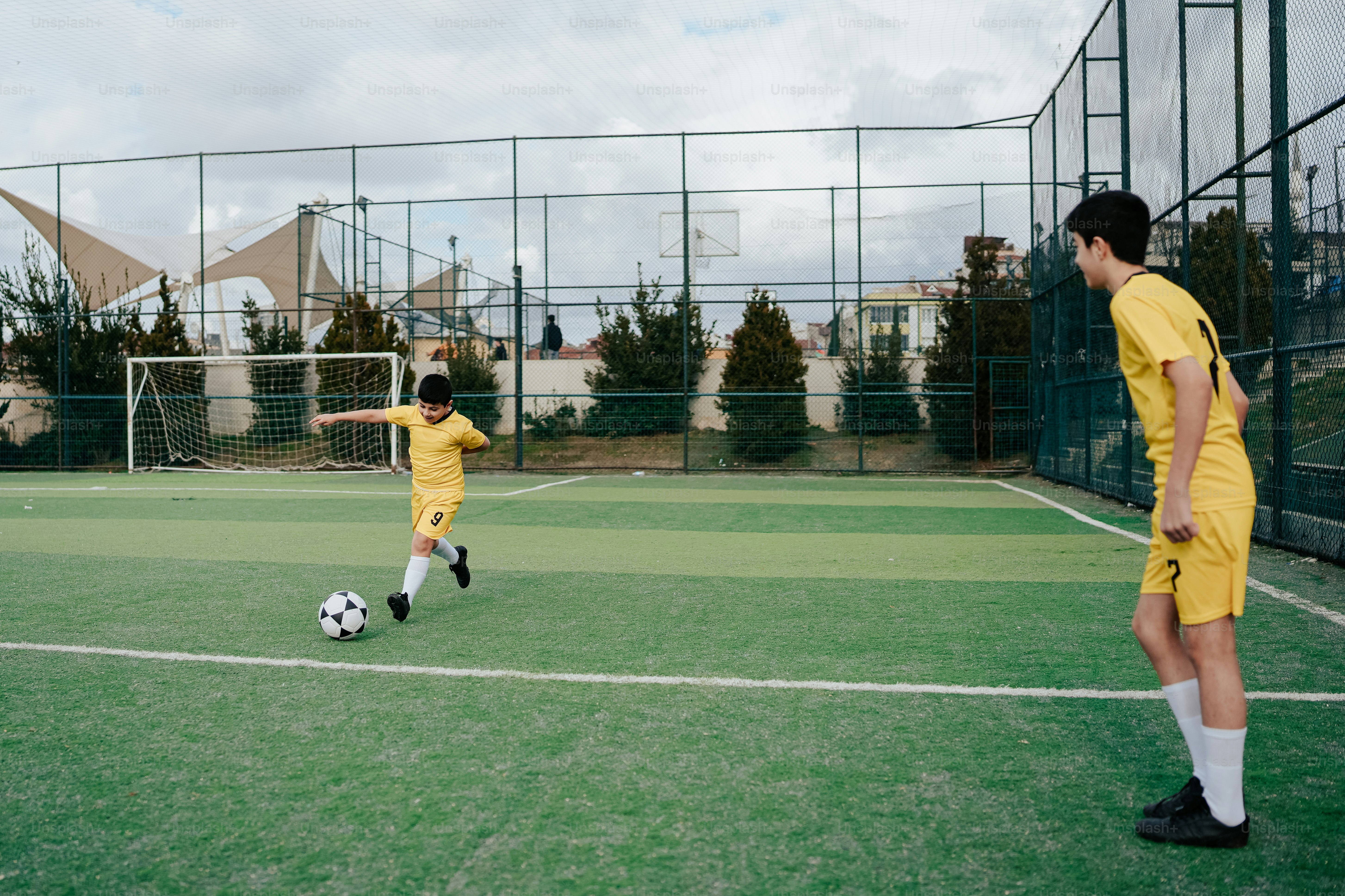 a couple of young men kicking around a soccer ball
