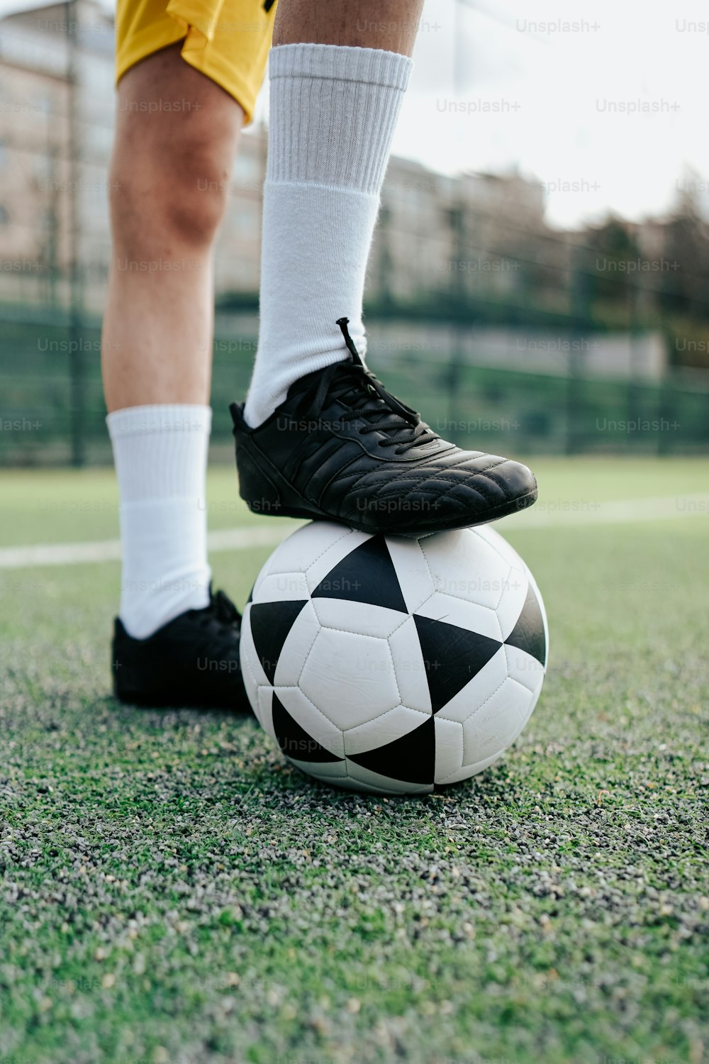Un jugador de fútbol está parado sobre un balón de fútbol