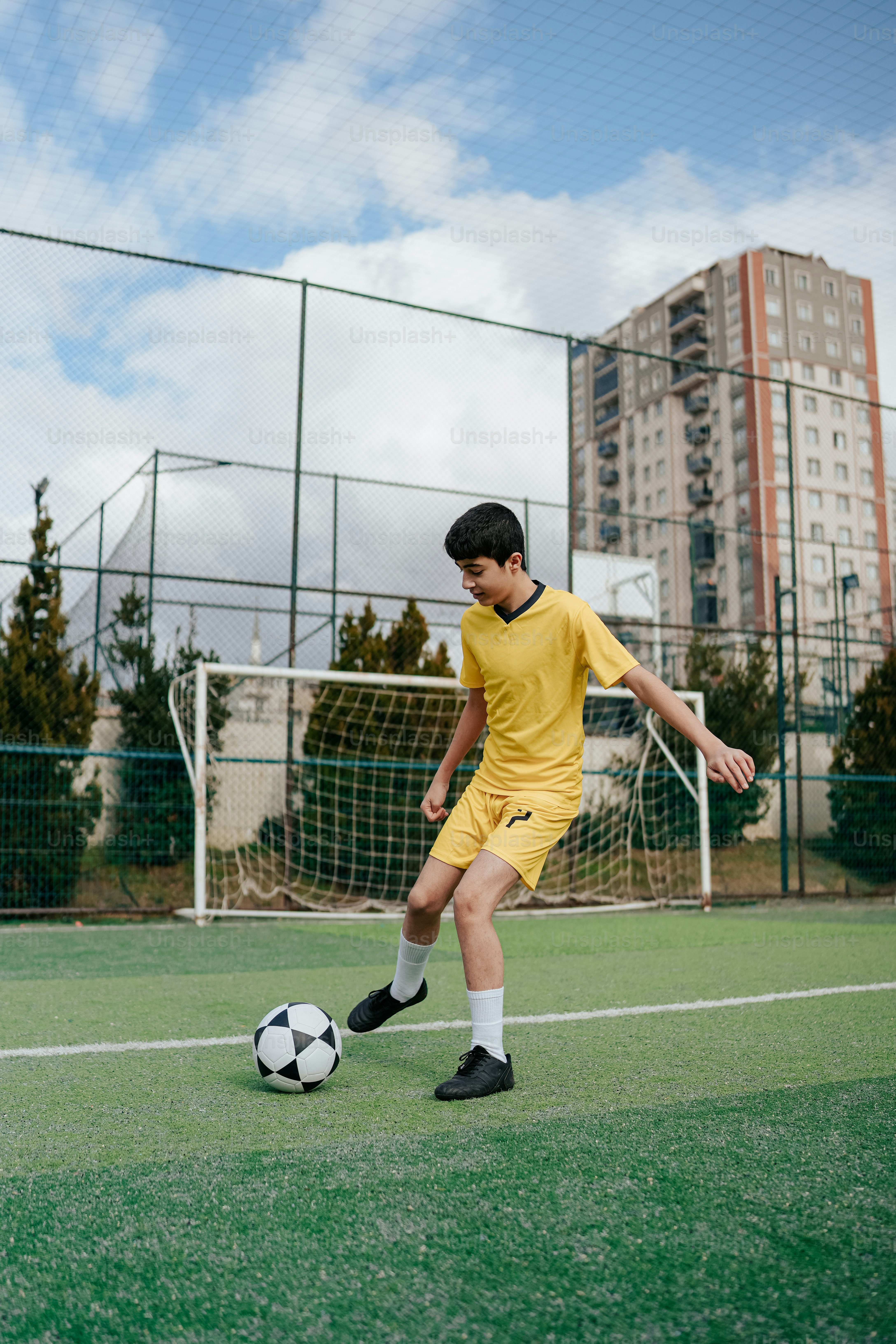 A couple of young men kicking around a soccer ball photo – Football ...
