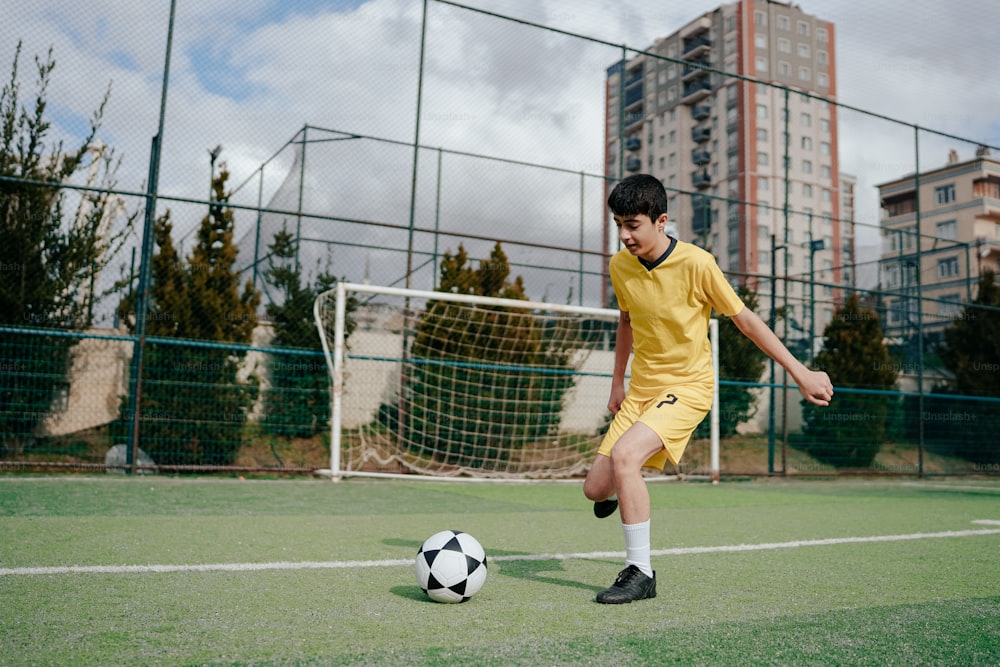 a young man kicking a soccer ball on a field