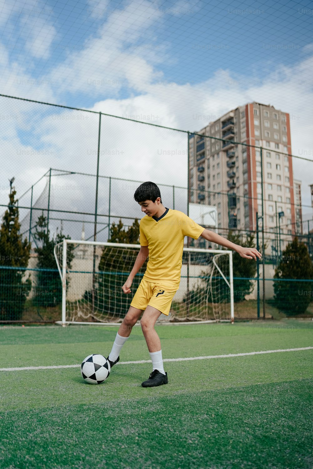 Un giovane che calcia un pallone da calcio su un campo