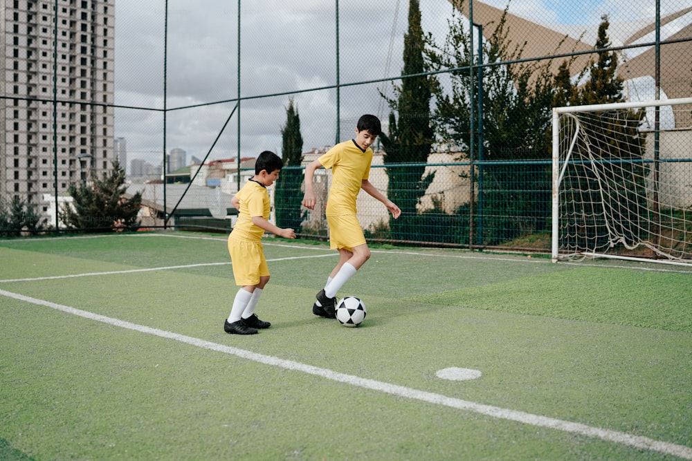 um casal de jovens chutando em torno de uma bola de futebol