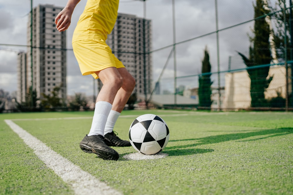 Un homme donnant un coup de pied dans un ballon de soccer sur un terrain