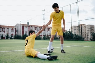 Un couple de jeunes hommes donnant des coups de pied autour d’un ballon de football