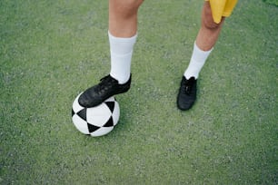 Una persona parada encima de un balón de fútbol