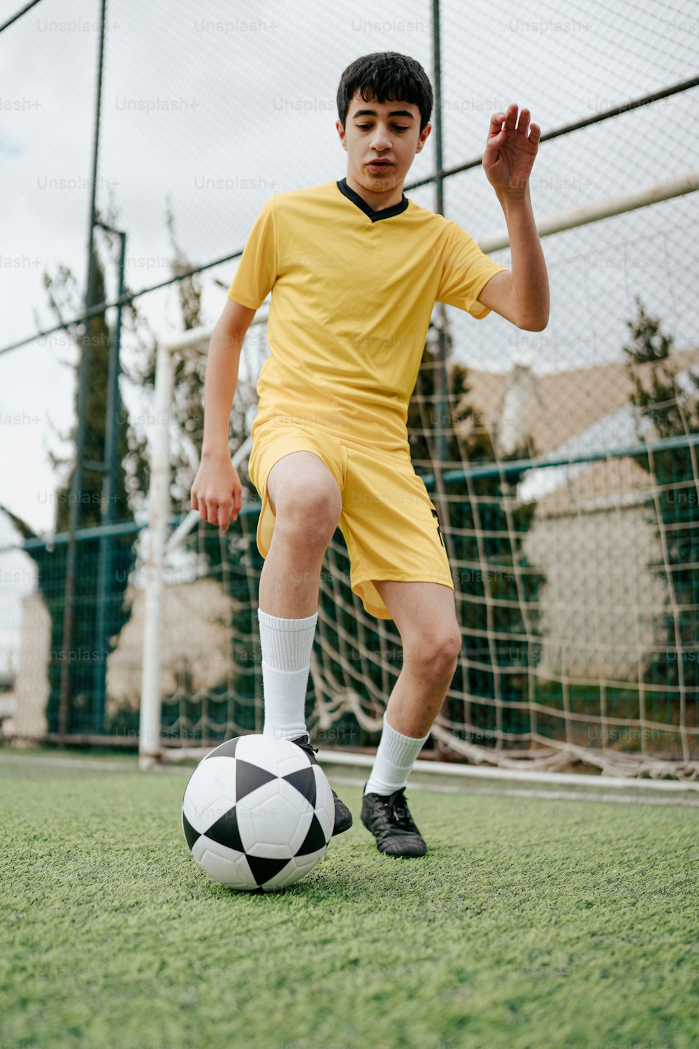 a young boy kicking a soccer ball on a field