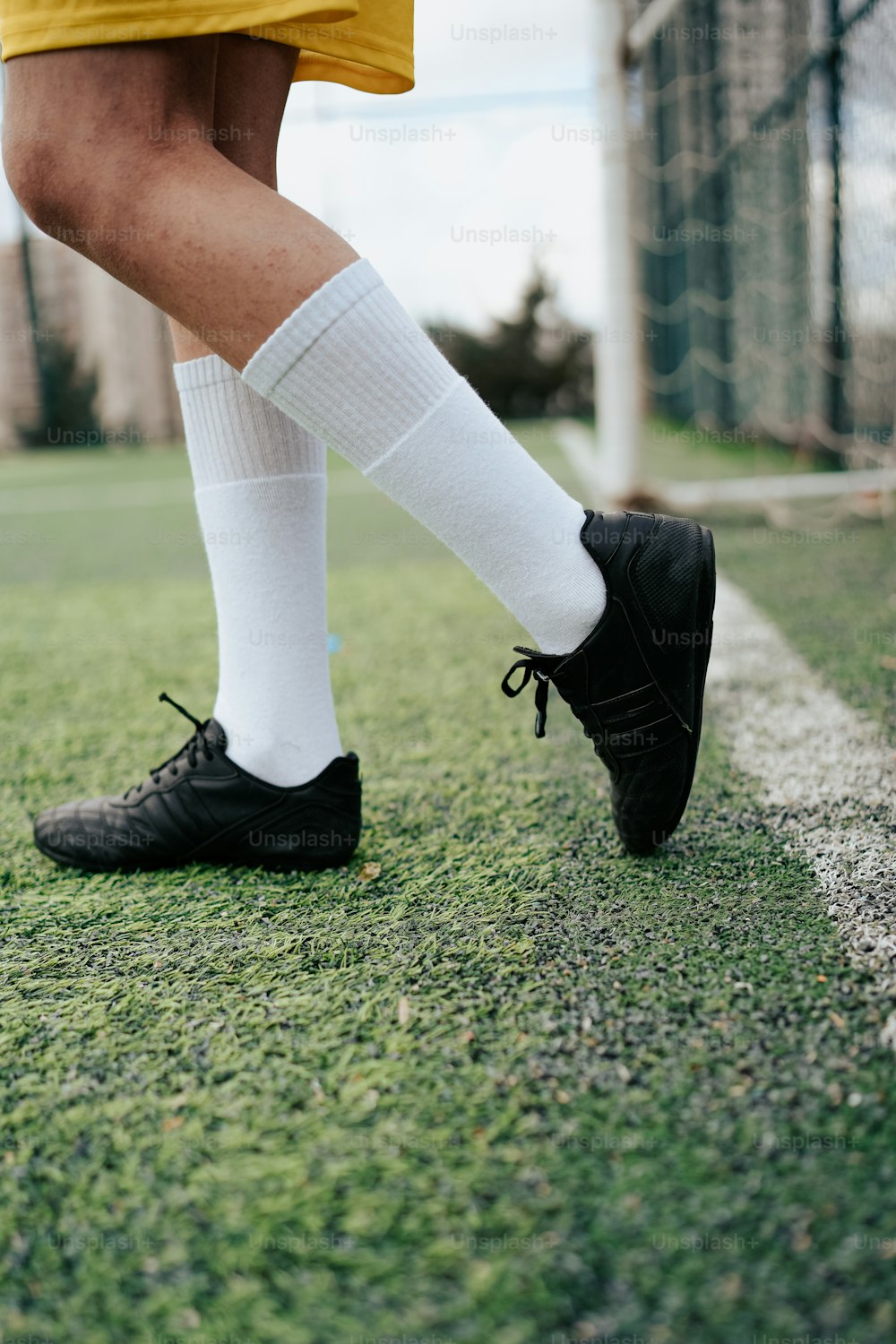 Un joueur de football en short jaune et chaussures noires