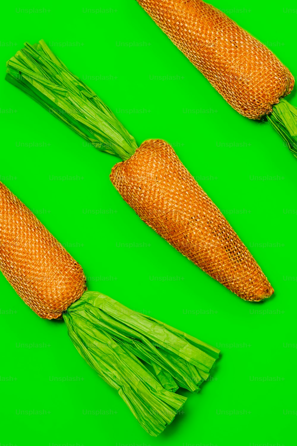 a group of three carrots sitting on top of a green surface