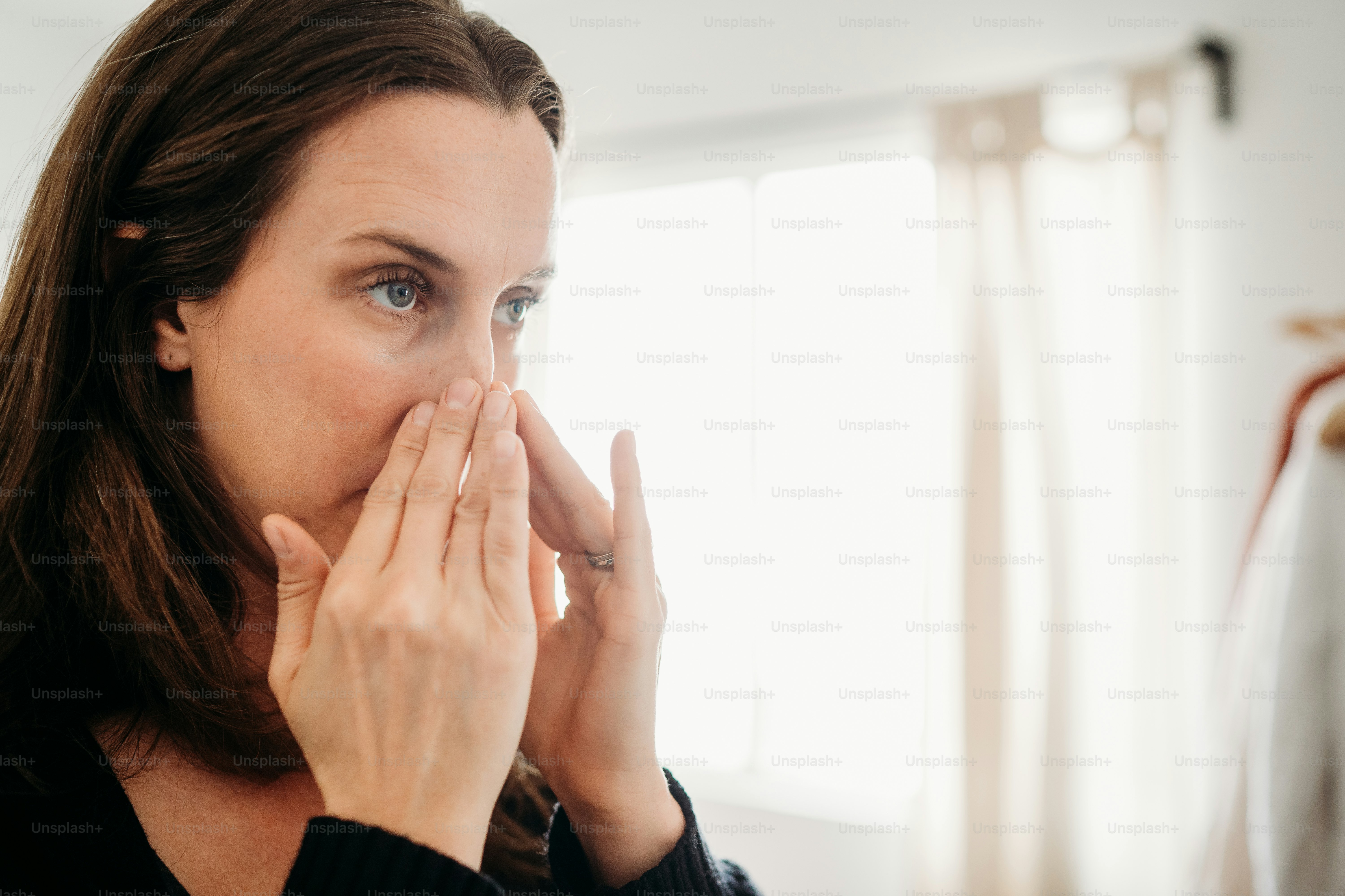 Una donna si copre la bocca con le mani