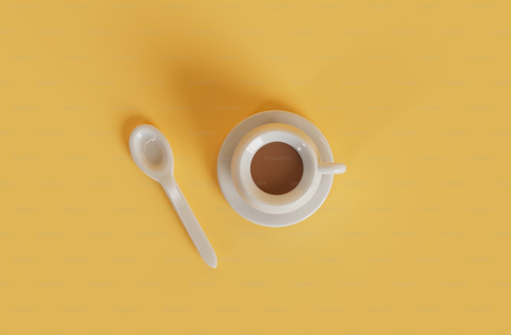 una tazza di caffè e un cucchiaio su sfondo giallo