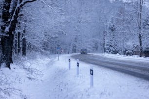 Ein Auto fährt eine schneebedeckte Straße hinunter