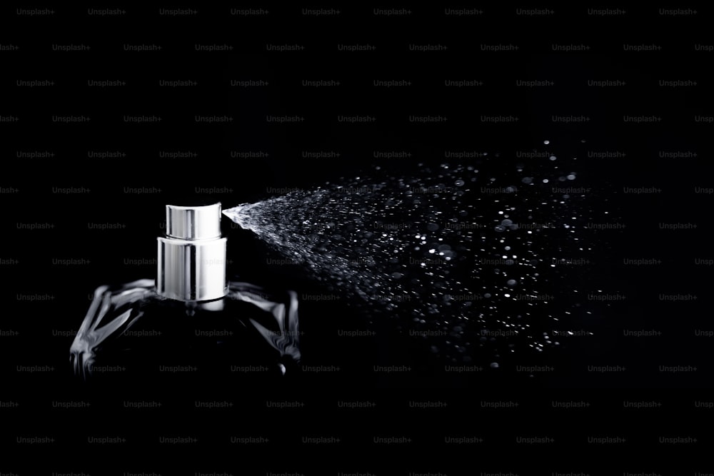 a spray bottle is spraying water on a black background