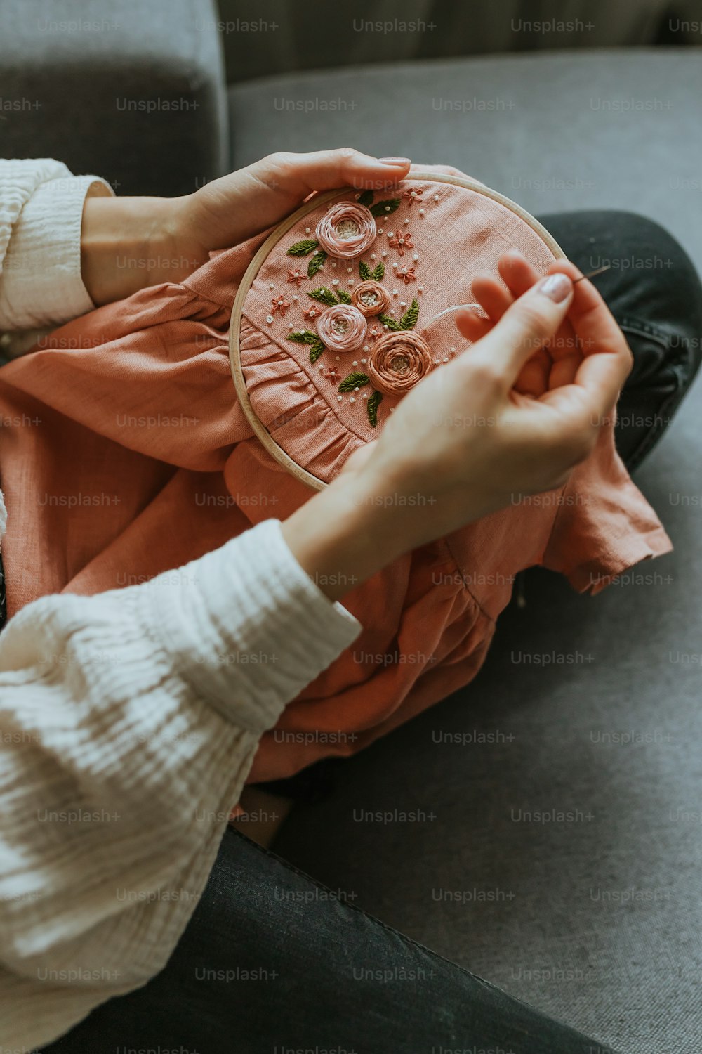 a woman is holding a piece of cloth with flowers on it