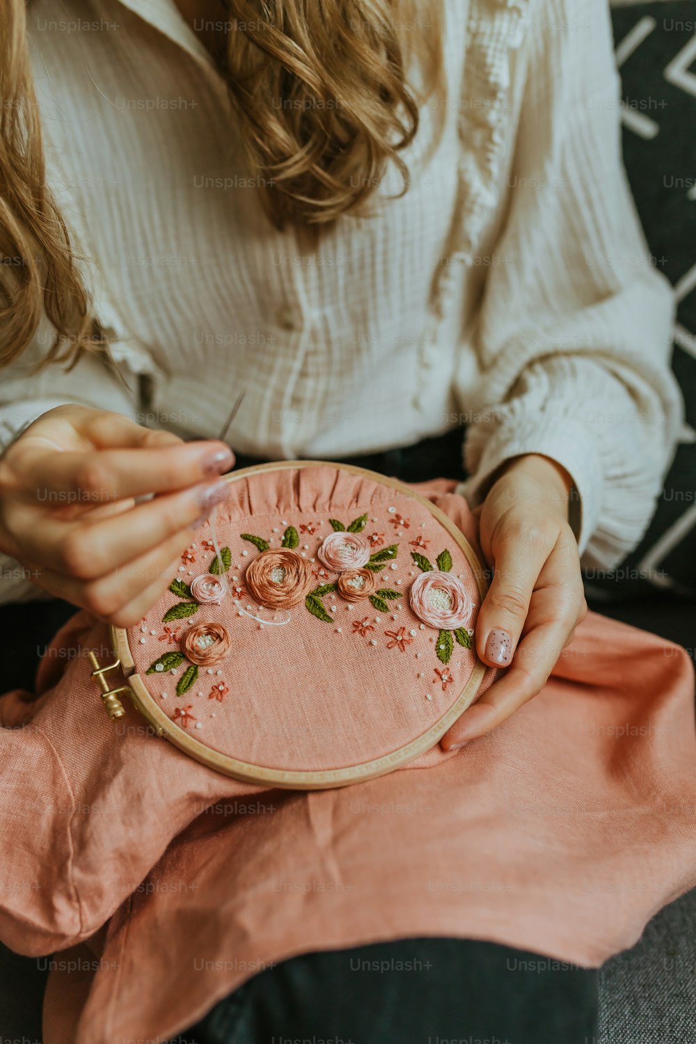 a woman sitting on a couch holding a pink purse