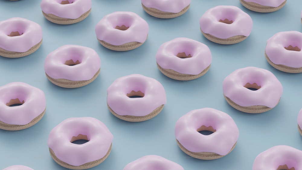 파란색 표면 위에 앉아 있는 분홍색 도넛 그룹
