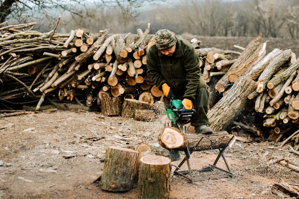 Un uomo che taglia la legna con una motosega