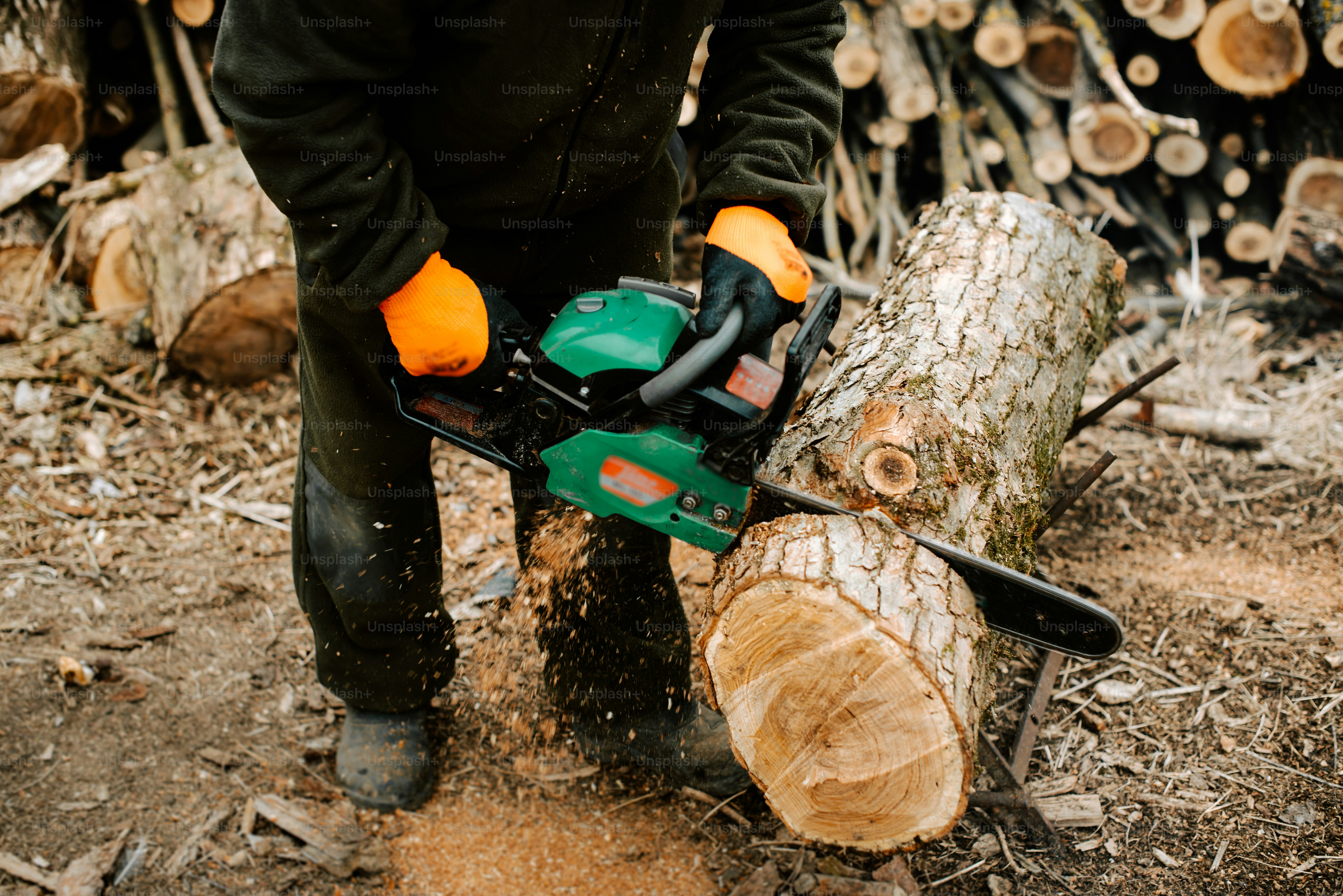 Un uomo che taglia un tronco con una motosega
