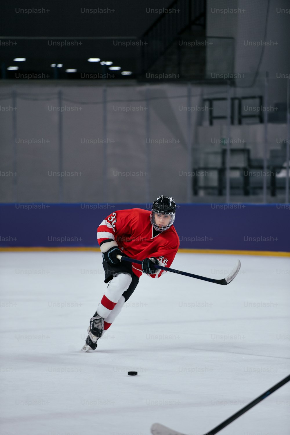 Un homme portant un chandail rouge joue au hockey