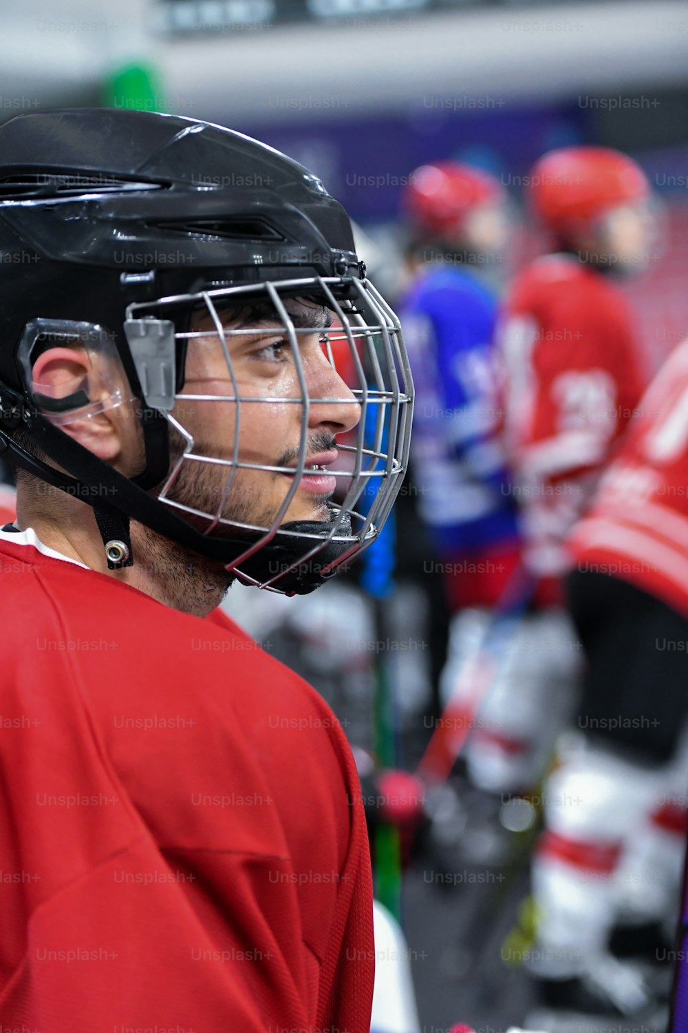 Un hombre con una camiseta roja con un casco de hockey