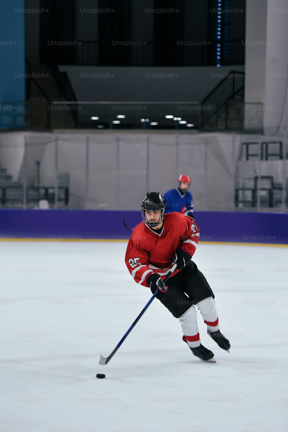 a man in a red jersey skating on an ice rink