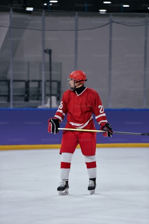 a man in a red hockey uniform holding a stick