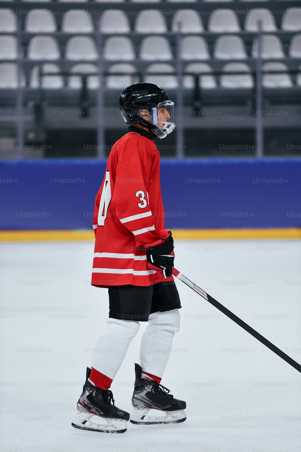 a hockey player in a red jersey holding a stick
