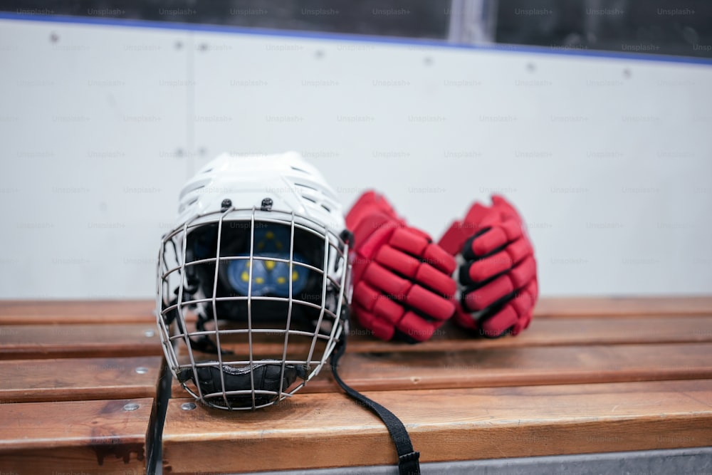 Helm und Handschuhe eines Hockeytorwarts auf einer Bank