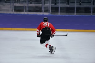 a man in a red jersey skating on an ice rink